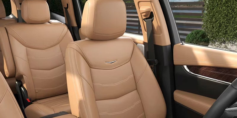 Close-up of the front-row leather seating inside the 2025 Cadillac XT6 with beige interior